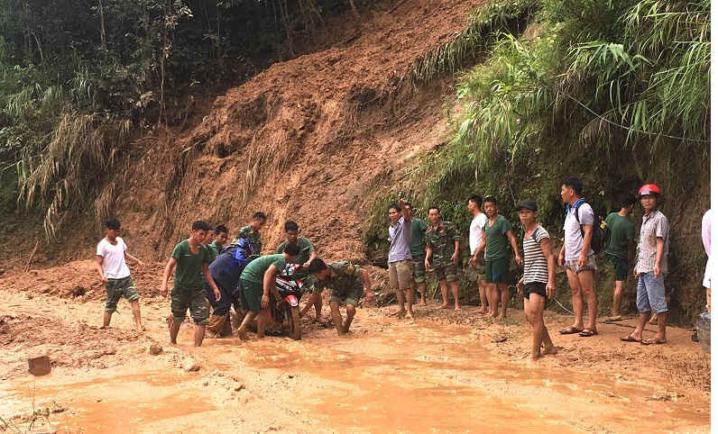 Lực lượng tại chỗ huyện Xín Mần (Hà Giang) giúp người dân di chuyển phương tiện qua các điểm sạt lở.