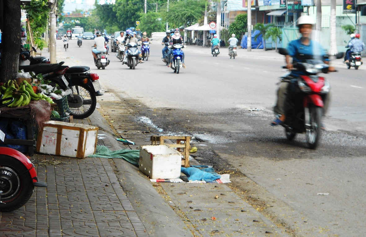 Người dân dùng bao bì, gạch, đá, thùng xốp bịt miệng các cụm hố ga thoát nước, ngăn mùi trên đường Hùng Vương (TP Quy Nhơn).