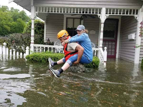 Một binh sĩ vệ binh quốc gia bang Texas cõng người phụ nữ trên lưng để cứu cô thoát khỏi khu vực bị ngập nước xung quanh Houston. Hình ảnh: HANDOUT / Reuters