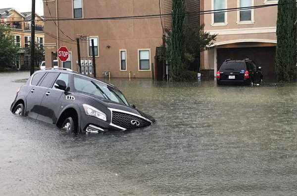 Một chiếc xe hơi chìm một phần hai trong khu dân cư ngập lụt của Houston. Ảnh: Reuters