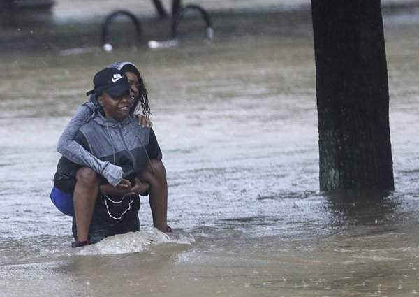 Cư dân Houston lội qua nước lụt. Ảnh: David J Phillip / AP