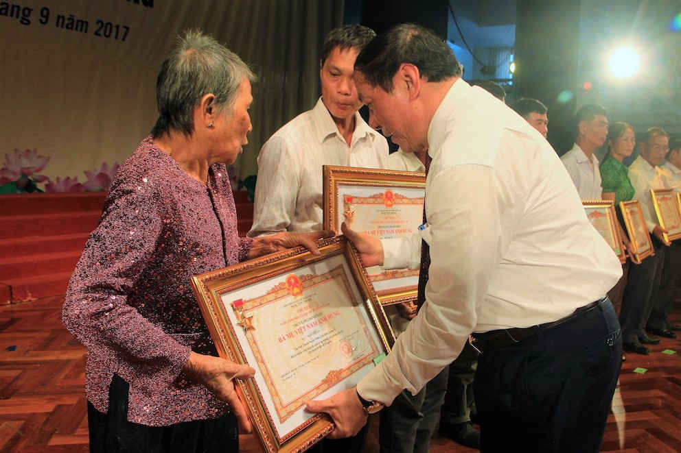 : Đồng chí Nguyễn Văn Hùng, UVTƯ Đảng, Bí thư Tỉnh ủy, Chủ tịch HĐND tỉnh Quảng Trị trao danh hiệu cho thân  nhân các mẹ được truy tặng