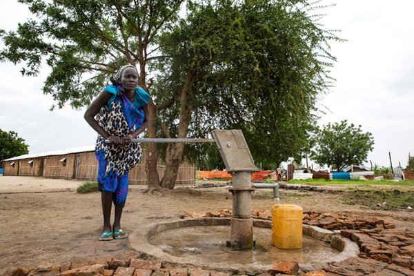 Angelina Nyakuma bơm nước vào một chiếc bình tại Trường tiểu học Machakos, Bentiu, South Sudan. Angelina sống ở thị trấn Bentiu và bán củi để kiếm sống. Bà nói cuộc sống của bà rất khó khăn trước khi có máy bơm nước gần nhà. Người mẹ của 6 đứa con này thường phải lấy nước từ sông và mất khoảng hai giờ đi bộ.