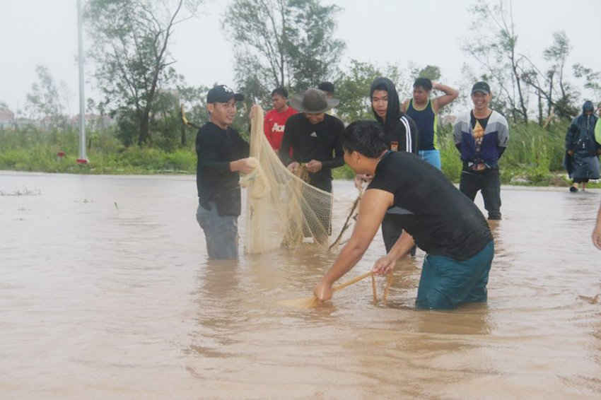 Nước ngập sâu hơn nữa đầu gối ở một số tuyến đường như Nguyễn Văn Linh, Hữu Nghị...; người dân Quảng Bình đã mang chài lưới thả, bắt cá
