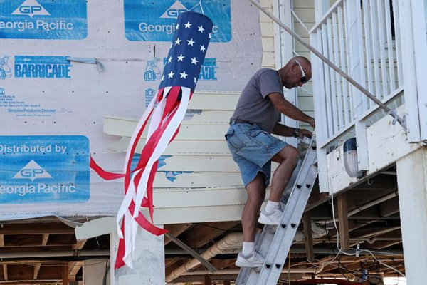 Người đàn ông leo xuống bậc thang sau siêu bão Irma ở Big Pine Key, Florida, Mỹ vào ngày 18/9/2017. Ảnh: REUTERS / Carlo Allegri