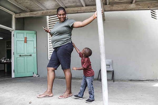 Aysha Punter mỉm cười với đứa con trai 3 tuổi của cô, Tyrese Joyce, ở St. John's, thủ đổ của đảo Antigua. Cô và gia đình hiện đang sống tại Trung tâm Đào tạo Kỹ thuật Quốc gia ở St. John's.