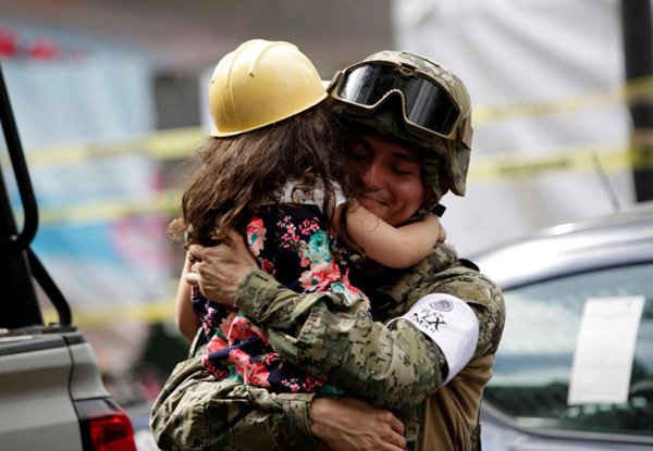 Bé gái ôm người sĩ quan hải quân Mexico gần một tòa nhà bị sập sau trận động đất ở thành phố Mexico. Ảnh: REUTERS / Jose Luis Gonzalez