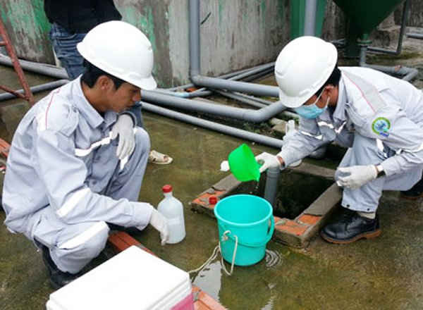 Cán bộ Trung tâm quan trắc môi trường (thuộc Sở TN&MT) lấy mẫu nước thải của một nhà máy để phân tích