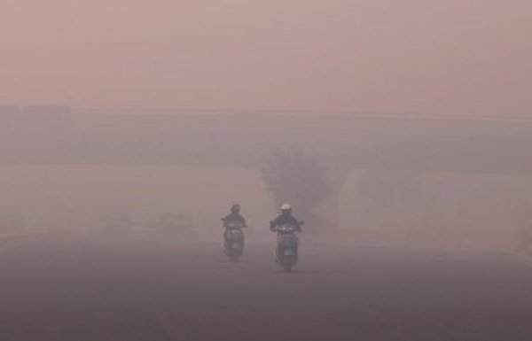 Những người đi làm đi qua khói bụi ở New Delhi, Ấn Độ vào ngày 31/10/2016. Ảnh: REUTERS/Adnan Abidi