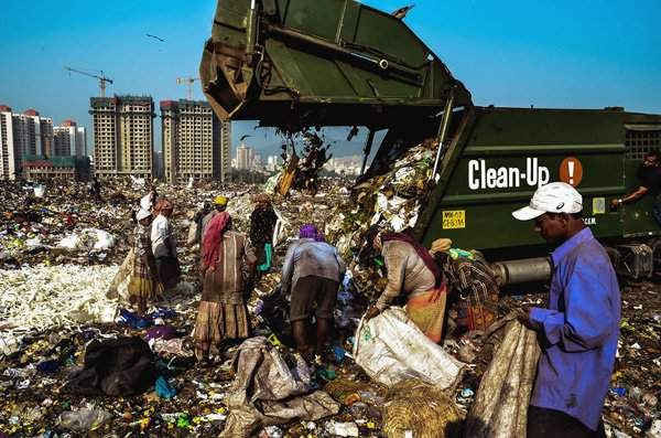 Đập Mulund là cơ sở xử lý rác thải lớn thứ hai ở Mumbai. Đống rác thải cao tới 28 mét. Một nhóm người thu gom nhựa và kim loại được đổ ra từ các xe chở rác. Không có công nhân nào đeo khẩu trang hoặc găng tay. Hình ảnh: Idrees Mohammed / National Geographic Your Shot