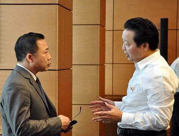 Bộ trưởng Trần Hồng Hà trao đổi với Đại biểu Lưu Bình Nhưỡng trong giờ giải lao bên hành lang Quốc hội sáng 24/10