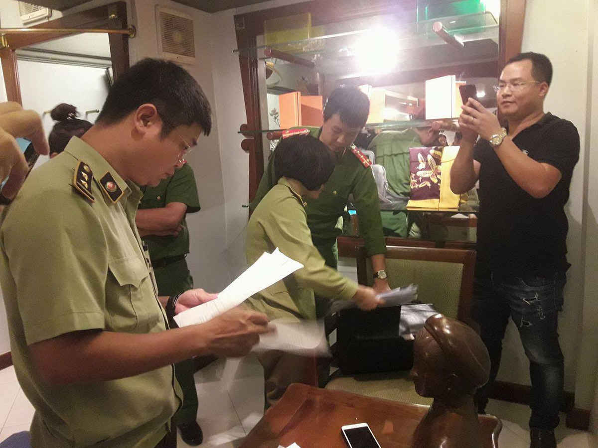 Lực lượng chức năng tiến hành lập biên bản và thu giữ mẫu hàng tại cửa hàng Khaisilk 113 Hàng Gai, Hà Nội 