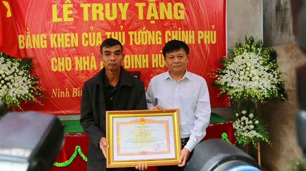 Đại diện Thông tấn xã Việt Nam trao tặng Bằng khen của Thủ tướng Chính phủ cho gia đình phóng viên Đinh Hữu Dư
