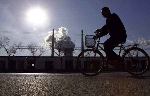Ống khói khói từ một nhà máy điện đốt than đằng sau một người đi xe đạp ở Bắc Kinh, Trung Quốc vào ngày 14/12/2010. Ảnh: REUTERS / David Gray