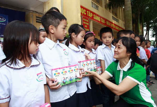 Bà Nguyễn Minh Tâm – Giám đốc Chi nhánh Vinamilk tại Hà Nội trao quà cho các em học sinh