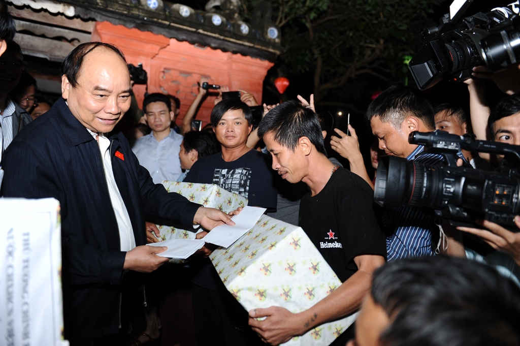 Thủ tướng Chính phủ tặng quà cho một gia đình ở khu phố cổ bị thiệt hại sau mưa lũ