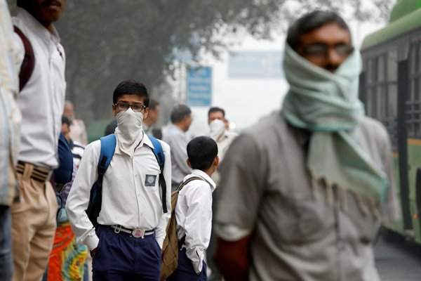 Một cậu học sinh che mặt bằng khăn tay khi đợi xe buýt vào một buổi sáng ô nhiễm do khói bụi tại New Delhi, Ấn Độ vào ngày 8/11/2017. Ảnh: REUTERS / Saumya Khandelwal