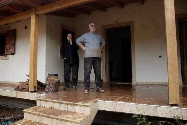 Người dân địa phương đứng tại cửa nhà bị phá hủy sau trận mưa lớn ở thị trấn Mandra, Hy Lạp vào ngày 15/11/2017. Ảnh: REUTERS / Alkis Konstantinidis