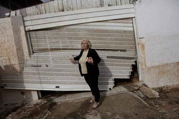 Konstantina Louka, một người dân địa phương đứng bên cạnh gara ô tô bị phá hủy sau trận mưa lớn tại thị trấn Mandra, Hy Lạp vào ngày 15/11/2017. : REUTERS / Alkis Konstantinidis