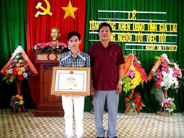 Phó Chủ tịch UBND huyện Krông Pa Tạ Chí Khanh trao bằng khen của Chủ tịch UBND tỉnh Gia Lai cho em Kiên