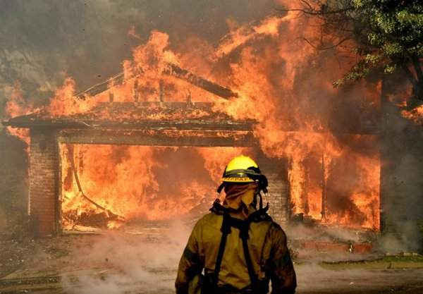 Nhân viên cứu hỏa chiến đấu với ngọn lửa để cứu một trong nhiều ngôi nhà đang cháy trong vụ cháy rừng Creek Fire ở khu vực Kagel Canyon, thung lũng San Fernando, phía Bắc Los Angeles vào ngày 5/12/2017. Ảnh: Reuters / Gene Blevins