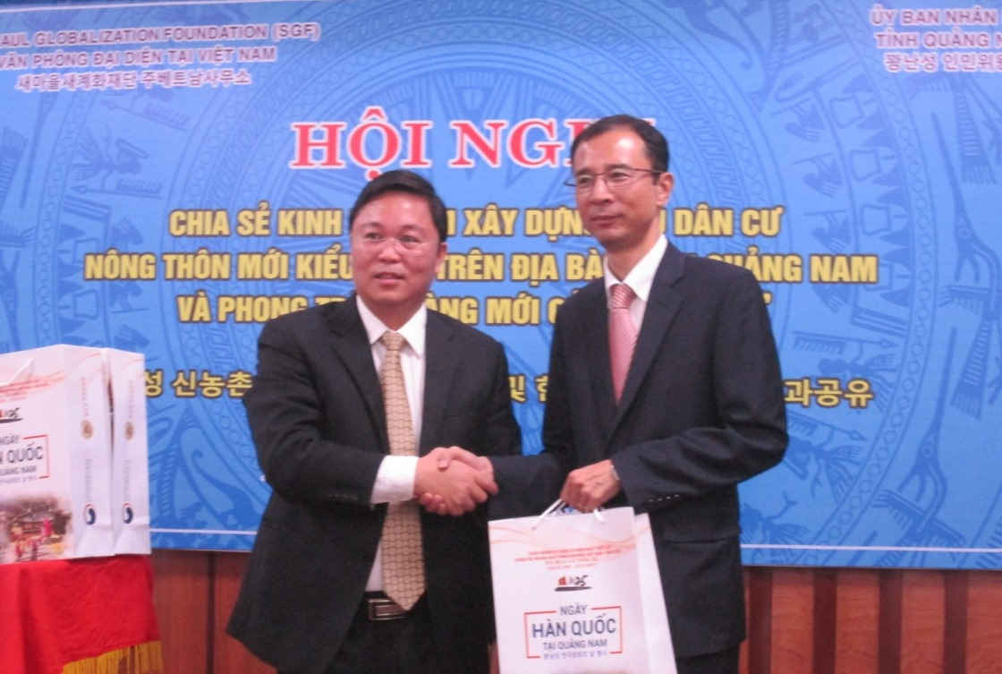Phó Chủ tịch UBND tỉnh Quảng Nam Lê Trí Thanh  tặng quà lưu niệm cho ông Lee Sang Woo - Trưởng Văn phòng đại diện Tổ chức “Làng mới của Hàn Quốc” tại Việt Nam.                                                                                            