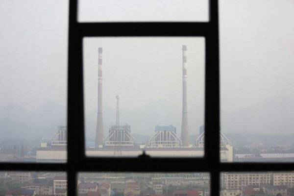 Các ống khói được nhìn thấy qua cửa sổ tại nhà máy điện đốt than vào một ngày sương mù ở quận Shimen, tỉnh Hunan,Trung Quốc vào ngày 2/6/2014. Ảnh: U.S. Reuters / Jason Lee