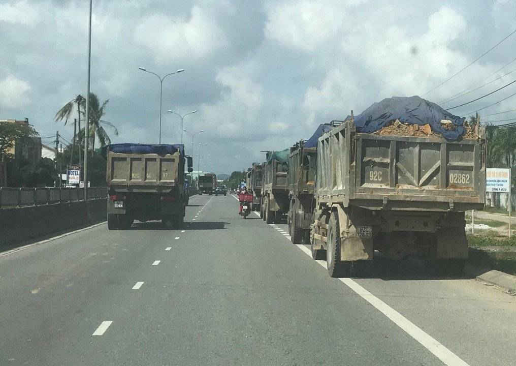 Trên QL1A đoạn qua huyện Núi Thành, xe tải chở đất “có ngọn” chạy nối nhau thành hành dài mà không cơ quan chức năng nào thăm hỏi