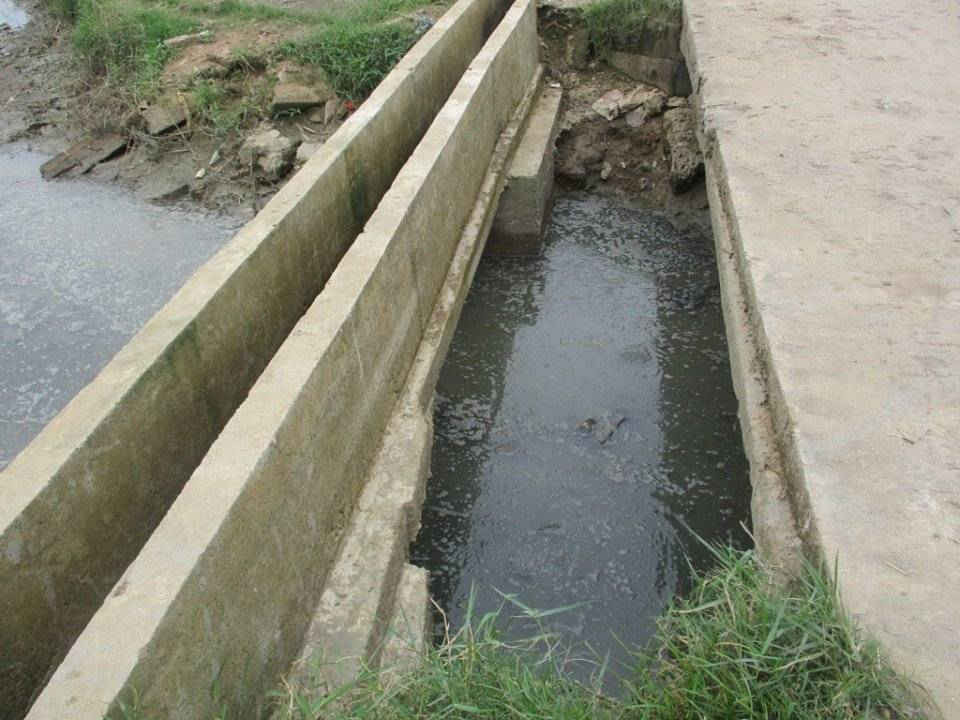 Nước thải sản xuất bún và nước chăn nuôi heo chảy ra mương nước phục vụ tươi tiêu gây mùi hôi thối ô nhiễm môi trường trong Làng nghề Bún tươi Ngãi Chánh