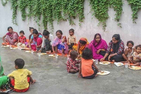 Những người hứng chịu lũ lụt ở khu vực Jyoti Nagar đang ngồi ăn ở một trại cứu trợ ở Birgunj 