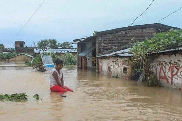 Một phụ nữ bất lực nhìn ngôi nhà bị ngập nước của cô 