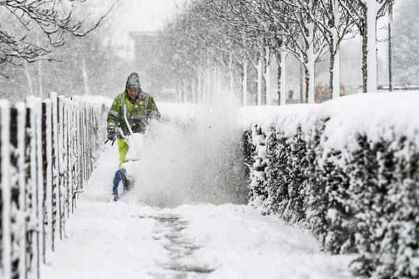Một nhân viên môi trường dọn tuyết bằng máy từ vỉa hè ở Harthill, Scotland. Hình ảnh: Jeff J Mitchell / Getty Images