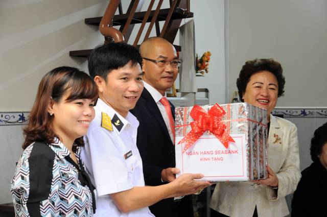 Bà Nguyễn Thị Nga - Chủ tịch HĐQT SeABank trao quà mừng tân gia cho Trung tá Long.