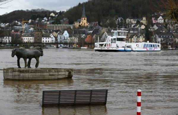 Tác phẩm điêu khắc và một ghế đá công viên bị ngập dưới sông Rhine khi thị trấn Linz được nhìn thấy trong hậu cảnh ở Đức vào ngày 5/1/2018. Ảnh: Reuters / Wolfgang Rattay