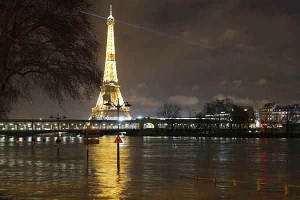 Một ngọn đèn đường và các biển báo bị ngập nước. Hình ảnh: Christophe Ena / AP