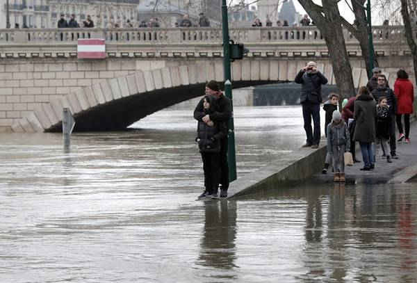 Những người dân đứng bên bờ sông Seine ngập nước. Ảnh: Maya Vidon-White/UPI/Barcroft Images