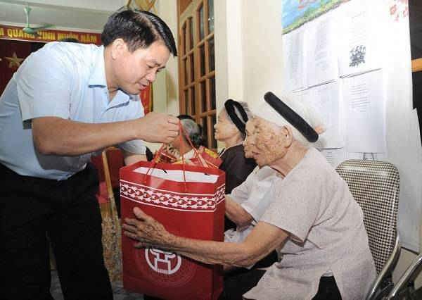 Chủ tịch UBND TP Hà Nội Nguyễn Đức Chung tặng quà người có công. Ảnh: Báo LĐTĐ.