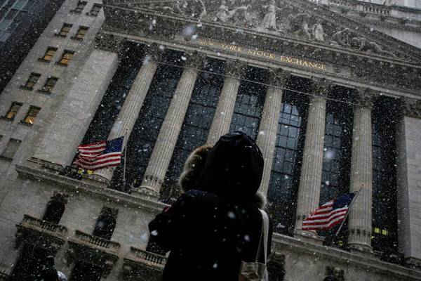 Một người phụ nữ dừng lại để chụp ảnh Sở giao dịch Chứng khoán New York (NYSE) khi tuyết bắt đầu rơi vào buổi sáng ở thành phố New York, Mỹ vào ngày 7/2/2018. Ảnh: Reuters / Brendan McDermid