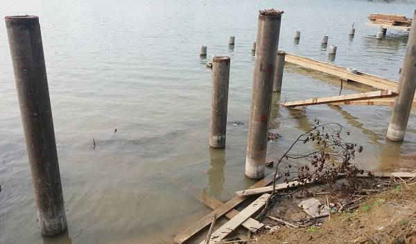 Các cọc bê tông được đóng xuống sông để làm tuyến đi bộ lát gỗ lim