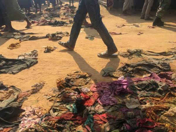 Một người đàn ông đi qua những bộ quần áo rách rưới bị người tị nạn Rohingya vứt bỏ tại trại tị nạn Kutupalong ở Bangladesh, ngày 12/2/2018. Ảnh: Andrew RC Marshall
