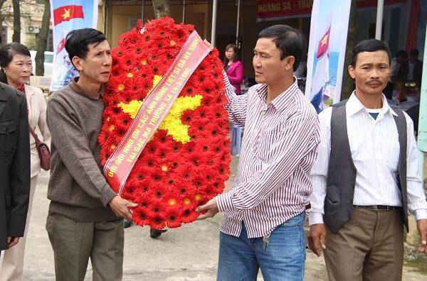 Cựu binh Trần Thiên Phụng (bên trái) cùng đồng đội kết vòng hoa tưởng nhớ các liệt sĩ Gạc Ma