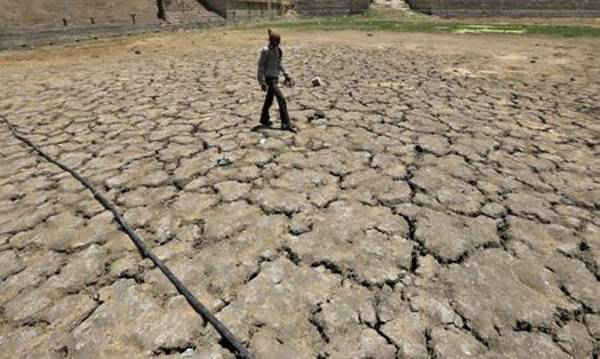 Một người đàn ông đi qua hồ Sarkhej khô cằn vào một ngày hè nóng nực ở Ahmedabad, Ấn Độ, ngày 21/4/2016. Ảnh: Amit Dave