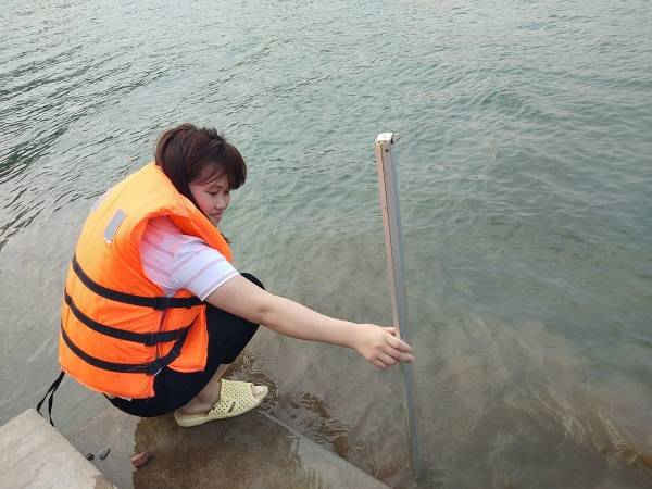 Quan trắc viên Nguyễn Thị Loan đo mực nước và nhiệt độ nước sông Đà
