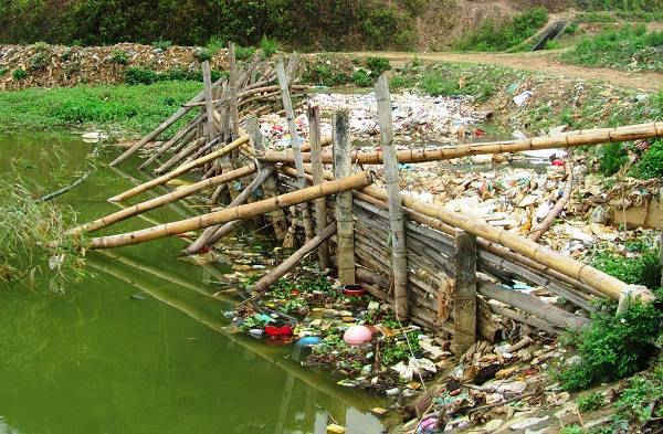 Người dân phải đóc cọc, làm rào chắn rác để hạn chế rác thải tràn lan ra lòng hồ