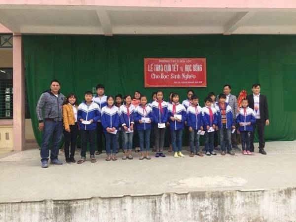 Anh Nguyễn Văn Bình (ngoài cùng bên trái) trao quà và học bổng các học sinh khó khăn trong xã Hòa Lộc.