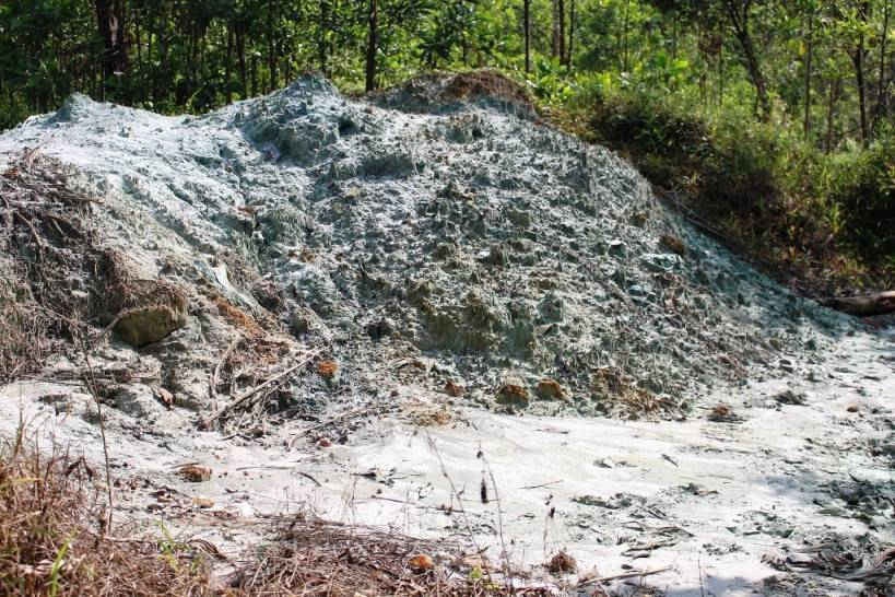 Các bãi đống đất xái quặng màu xanh đổ ra mặt đất bốc mùi hóa chất