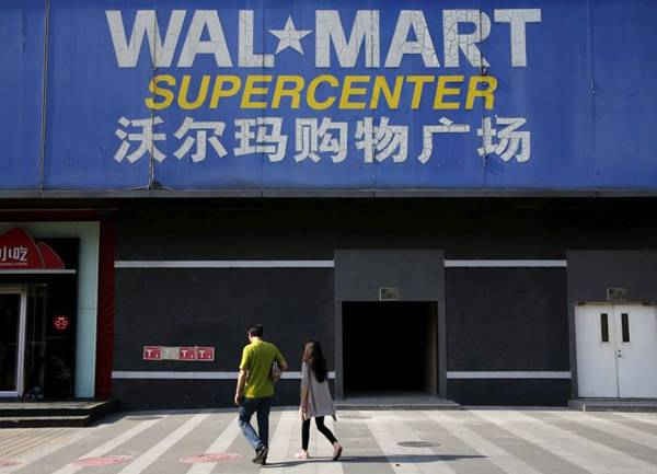 Hai người đi bộ đi qua cửa hàng chi nhánh của Walmart tại Bắc Kinh, Trung Quốc vào ngày 15/10/2015. Ảnh: Kim Kyung Hoon / Reuters