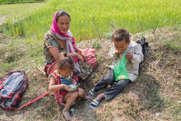 Một cậu bé ăn cơm đựng trong túi nilon gần cánh đồng lúa bên bờ sông Bagmati ở Thung lũng Kathmandu. Mọi người không biết rằng những loại túi này sẽ được xả đến điểm cuối ở sông Bagmati. Ảnh: Nabin Baral