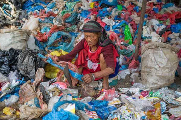 Một phụ nữ cắt túi nilon được thu nhặt từ Trung tâm thu gom rác của khu vực đô thị Katmandu. Một số túi polythene rác được tái chế, nhưng một số được đổ vào các cánh đồng và sông của Thung lũng Kathmandu. Ảnh: Nabin Baral