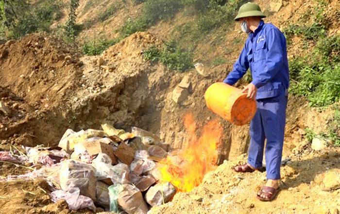 Lực lượng chức năng tỉnh Lào Cai đang tiên hành tiêu hủy số cá tầm đông lạnh, gà cay và số chân gà không rõ nguồn gốc. 